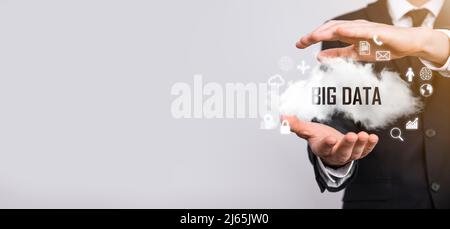 Geschäftsmann hält die Inschrift , Wort BIG DATA . Vorhängeschloss, Gehirn, Mann, Planet, Graph, Lupe, Zahnräder, Symbol für Cloud, Grid, Dokument, Brief, Telefon Stockfoto
