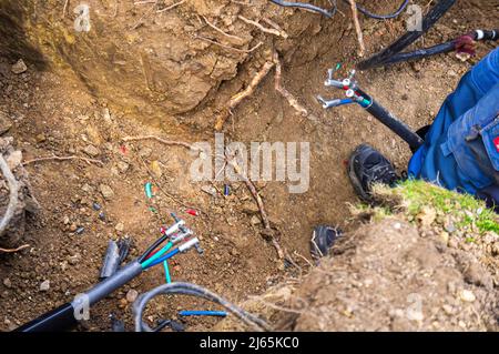 Beschädigte Erdkabel beim Graben, eingerastet, defektes Stromleitungskabel, Verkabelung, defekte Stromleitung, Reparatur, Pruhonice, Tschechische Republik am 26. April 2 Stockfoto