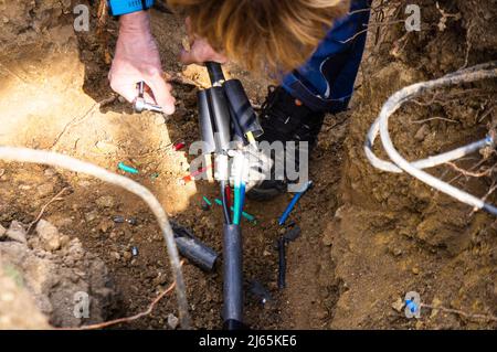 Beschädigte Erdkabel beim Graben, eingerastet, defektes Stromleitungskabel, Verkabelung, defekte Stromleitung, Reparatur, Pruhonice, Tschechische Republik am 26. April 2 Stockfoto
