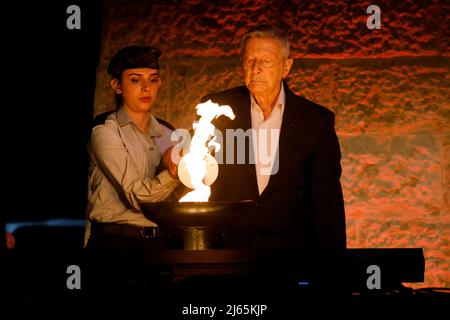 (220428) -- JERUSALEM, 28. April 2022 (Xinhua) -- Ein Holocaust-Überlebender zündet bei der Eröffnungsfeier des Holocaust-Gedenktages in Yad Vashem, Israels offiziellem Holocaust-Mahnmal, am 27. April 2022 in Jerusalem eine Fackel an. Im israelischen Holocaust-Gedenkmuseum wurde eine Zeremonie zum Holocaust-Gedenktag zu Ehren der sechs Millionen jüdischen Opfer der Nazis während des Zweiten Weltkriegs abgehalten. (JINI via Xinhua) Stockfoto