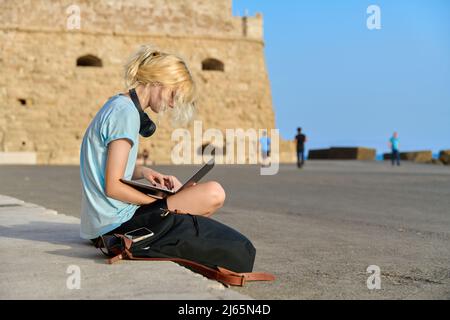 Teenager-Frau mit Laptop, alte europäische historische Festung Hintergrund. Stockfoto