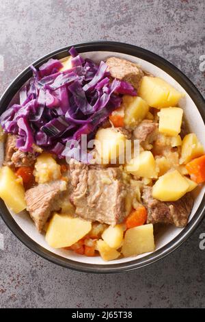 English Scouse ist ein Eintopf von Rind- oder Lammfleisch mit Gemüse in der Nähe auf dem Teller auf dem Tisch. Vertikale Draufsicht von oben Stockfoto