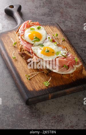 Strammer Max ist ein traditionelles Sandwich-Gericht in deutscher Küche aus der Nähe auf dem Holzbrett auf dem Tisch. Vertikal Stockfoto