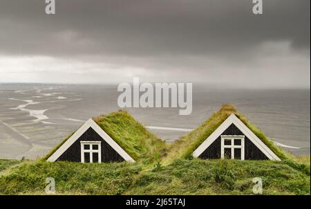 Museumshof Sel im Skaftafell Nationalpark, Insel. Im Hintergrund die Schotterebene des Skeiðarársandur unter bedrohten Wolken. Stockfoto