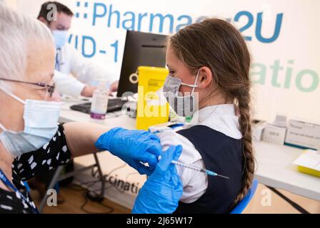 REDAKTIONELLE VERWENDUNG NUR Thea Matthewman, 11, aus Maidstone, einem der ersten Kinder im Alter von 5 bis 11 Jahren, das den Pfizer BioNTech-Impfstoff im Impfzentrum Pharmacy2U Covid-19 in Maidstone, Kent, erhalten hat. Ausgabedatum: Donnerstag, 28. April 2022. Stockfoto