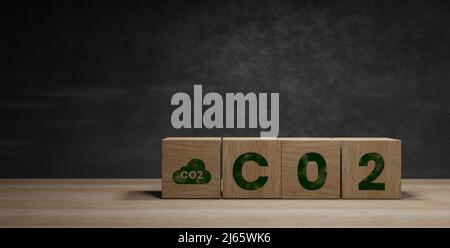 Holzwürfelblöcke mit CO2 (Kohlendioxid), ändern Sie sich in den Text H2 (Wasserstoff) auf dem Tabellenhintergrund. Free Carbon, alternative Energie und globales Klima cha Stockfoto