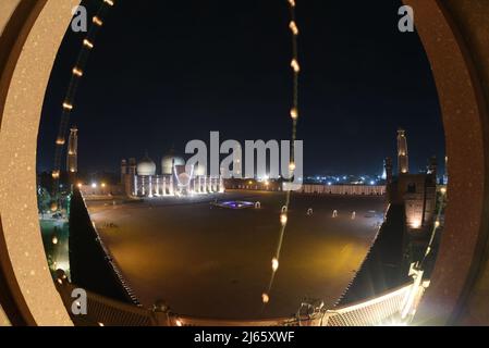 Lahore, Punjab, Pakistan. 27. April 2022. Eine attraktive herrliche atemberaubende Luftaufnahme der historischen Mughal Era Badshahi Moschee mit Lichtern geschmückt, um die heilige Nacht zu markieren und göttliche Segnungen von Lailatul Qadr, auch bekannt als die Nacht der Macht in Lahore zu suchen. Laylat ul Qadr oder allgemein bekannt als Shab-e-Qadr, die ''˜Nacht der Macht' ist voller Segnungen, weil der bedeutende Koran in ihr abstammt, muslimische Anbeter kommen, um Abendgebete 27. Nacht des Heiligen Monats Ramadan an einer beleuchteten Badshahi-Moschee zu bieten'', so die Tradition, Als das muslimische heilige Buch, der Koran, enthüllt wurde Stockfoto