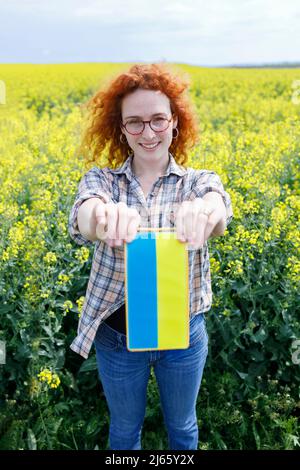 Kleines ukrainisches Banner in den Händen einer jungen Frau Stockfoto