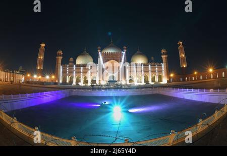 Lahore, Punjab, Pakistan. 27. April 2022. Eine attraktive herrliche atemberaubende Luftaufnahme der historischen Mughal Era Badshahi Moschee mit Lichtern geschmückt, um die heilige Nacht zu markieren und göttliche Segnungen von Lailatul Qadr, auch bekannt als die Nacht der Macht in Lahore zu suchen. Laylat ul Qadr oder allgemein bekannt als Shab-e-Qadr, die ''˜Nacht der Macht' ist voller Segnungen, weil der bedeutende Koran in ihr abstammt, muslimische Anbeter kommen, um Abendgebete 27. Nacht des Heiligen Monats Ramadan an einer beleuchteten Badshahi-Moschee zu bieten'', so die Tradition, Als das muslimische heilige Buch, der Koran, enthüllt wurde Stockfoto