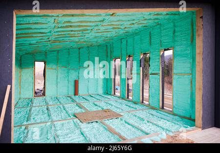 Holzrahmenhaus im skandinavischen Stil, wärmeisoliert mit Polyurethanschaum. Bau- und Isolierkonzept. Stockfoto