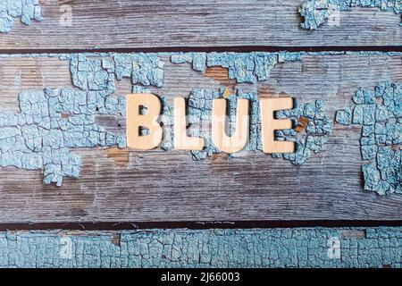 Blaues Wort auf Holzbuchstaben geschrieben Text auf einer strukturierten blauen Oberfläche Stockfoto