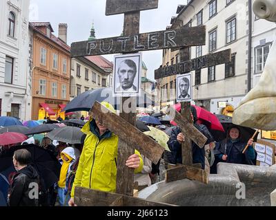 Menschen mit Putins Plakaten auf Kreuzigungskreuz und Inschrift Putters, gleichgesetzt mit Hitler, protestieren gegen den Krieg in der Ukraine und die Invasion von Stockfoto