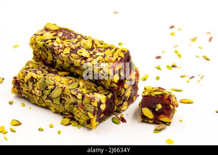 Türkisches Vergnügen. Türkischer Genuss mit Pistazien und Granatapfel, isoliert auf weißem Hintergrund. Traditionelle türkische Küche Delikatessen. Nahaufnahme Stockfoto