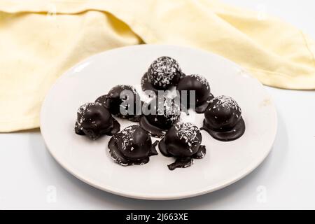 Dunkle Schokolade mit Kokosnussfüllung. Spezielle Pralinen auf weißem Hintergrund. Nahaufnahme Stockfoto