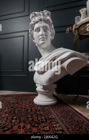 Büstenskulptur von Gott Apollo. Altgriechischer gott der Sonne und Poesie Gipskopie einer Marmorstatue, isoliert auf Schwarz Stockfoto