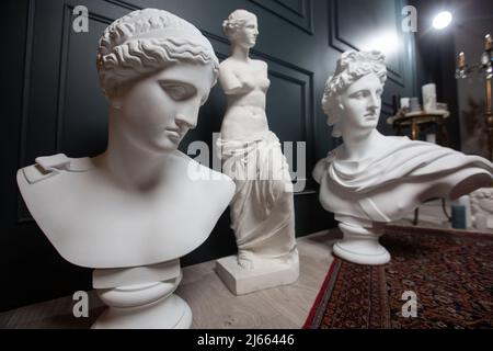 Gipskopie der antiken Statue Apollo, Aphrodite und Venus auf dunklem texturierten Hintergrund. Gipsskulptur Gesicht Stockfoto