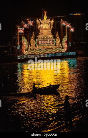 Phnom Penh, Kambodscha. November 13., 2016. Phnom Penh feiert, Bon Om Touk, das kambodschanische Wasserfest. Silhouette eines kleinen Bootes, wie es vor einem beleuchteten Schwimmer auf dem Tonle SAP River vorbeifährt. Das Wasserfest markiert die Umkehrung der Strömung im Tonle SAP Fluss, das Festival dauert 3 Tage und zieht bis zu 2 Millionen Besucher an, dieses Jahr ist es vom 13.. Bis 15.. November. Kredit: Kraig Lieb / Alamy Live Nachrichten Stockfoto