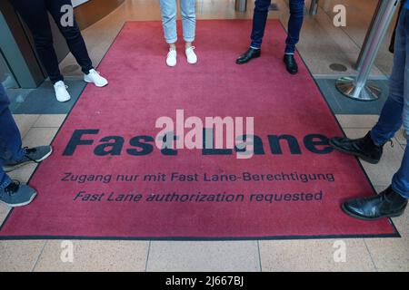 Hamburg, Deutschland. 28. April 2022. Medienvertreter stehen auf einem roten Teppich mit der Aufschrift „Fast Lane“ vor dem biometrischen Gesichtsfelderkennungssystem an der Sicherheitskontrolle im Abflugbereich des Hamburger Flughafens. Der neue Service steht Star Alliance-Passagieren (Österreich, Schweiz und Lufthansa) zur Verfügung, die am Miles & More Treueprogramm teilnehmen. Passagiere erhalten kontaktlosen Zugang zum Sicherheitskontrollpunkt und zum Boarding. Eine Bordkarte oder ein Smartphone müssen nicht mehr vorgelegt werden. Kredit: Marcus Brandt/dpa/Alamy Live Nachrichten Stockfoto