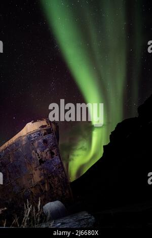 Aurora Borealis über dem alten Schiffsrack in Djúpavík, Westfjorde, Island - Nordlichter über einem alten Schiffswrack in den isländischen westfjorden Stockfoto