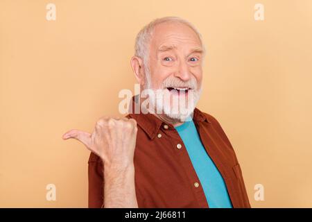 Foto von beeindruckt ältere grau Frisur Mann Index promo tragen Outfit isoliert auf beige Farbe Hintergrund Stockfoto