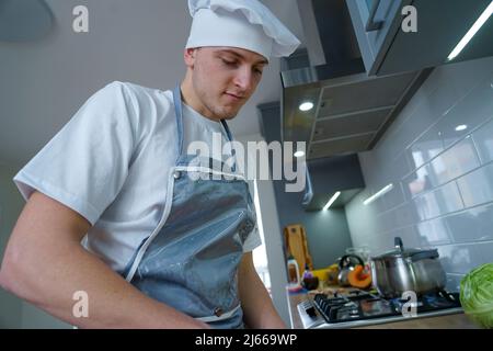 Der Küchenchef bereitet in der Küche Speisen zu Stockfoto