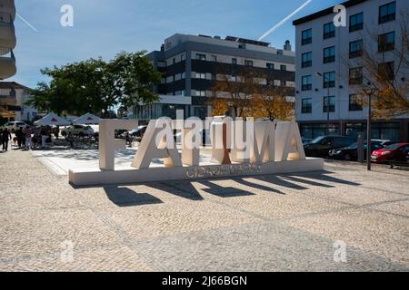 Fatima, Portugal - november 13 2022 - Menschen genießen die Sonne auf einem Platz neben dem Namensschild der Stadt Stockfoto