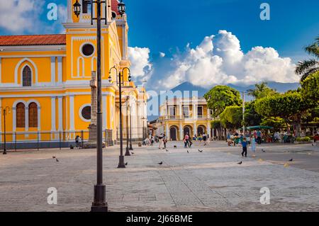 Wunderschöner platz mit Menschen bei Sonnenuntergang, plaza mit einer Kirche mit Menschen um die Stadt, plaza de granada nicaragua Stockfoto