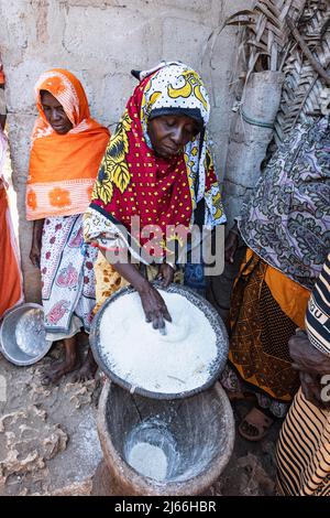 Frau mit Taromehl und grossem Moerser aus Holz, Tumgatu, Sansibar, Tansania Stockfoto