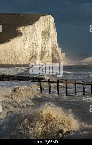 Wellen-Crash an Land vor den Seven Sisters Cliffs im Sturm Stockfoto