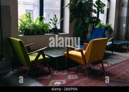 Tische und Stühle in einem leeren Café, Büro, Coworking oder Raum. Ein geschlossenes Restaurant. Aufgrund der globalen Krise gibt es keine Besucher. Stockfoto