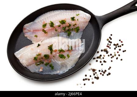 Weißes Fischfilet, bestreut mit grobem rosa Salz und Petersilie Stockfoto