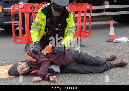 Kent, Großbritannien. 28. April 2022 Demonstranten von Just Stop Oil blockieren die BP-Garage bei Clacket Lane Services am M25. Die Polizei kommt, um alle Demonstranten zu entkleben und zu verhaften. Kredit: Denise Laura Baker/Alamy Live Nachrichten Stockfoto