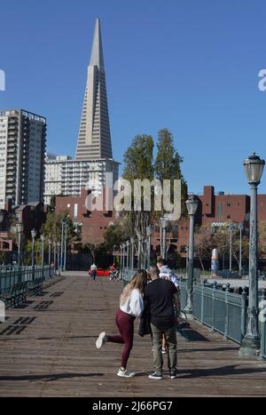 Touristen genießen den beliebten Pier 7 Angelpier mit seiner Fernsicht auf das Wahrzeichen Transamerica Pyramid Gebäude und die Skyline von San Francisco. Stockfoto