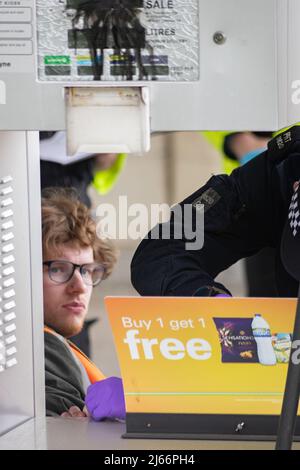 Kent, Großbritannien. 28. April 2022 Demonstranten von Just Stop Oil blockieren die BP-Garage bei Clacket Lane Services am M25. Die Polizei kommt, um alle Demonstranten zu entkleben und zu verhaften. Kredit: Denise Laura Baker/Alamy Live Nachrichten Stockfoto