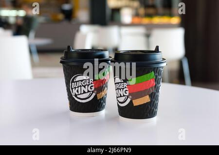 Russland, Tjumen - 10. Oktober 2021. Eine Tasse Burger King Kaffee auf dem Tisch im Café. Eine weltweite Fast-Food-Kette. Getränke in Einwegbechern. Stockfoto