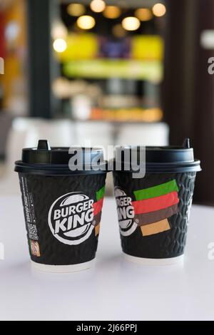 Russland, Tjumen - 10. Oktober 2021. Eine Tasse Burger King Kaffee auf dem Tisch im Café. Eine weltweite Fast-Food-Kette. Getränke in Einwegbechern. Stockfoto