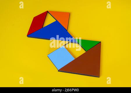 Bunte Zahl 8 mit Tangram-Spielzeug, farbige Tangram-Zahl sieben isoliert auf gelbem Hintergrund, Seitenansicht der siebten numerischen, Kinder Spielidee Stockfoto