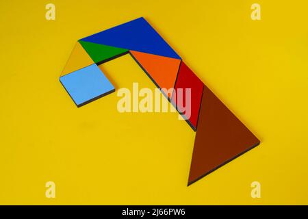 Bunte Zahl 7 mit Tangram-Spielzeug, farbige Tangram-Zahl sieben isoliert auf gelbem Hintergrund, Seitenansicht der siebten numerischen, Kinder Spielidee Stockfoto