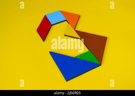 Bunte Zahl 3 mit Tangram-Spielzeug, farbige Tangram-Zahl sieben isoliert auf gelbem Hintergrund, Seitenansicht der siebten numerischen, Kinder Spielidee Stockfoto