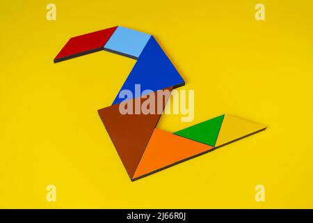 Bunte Zahl 2 mit Tangram-Spielzeug, farbige Tangram-Zahl sieben isoliert auf gelbem Hintergrund, Seitenansicht der siebten numerischen, Kinder Spielidee Stockfoto