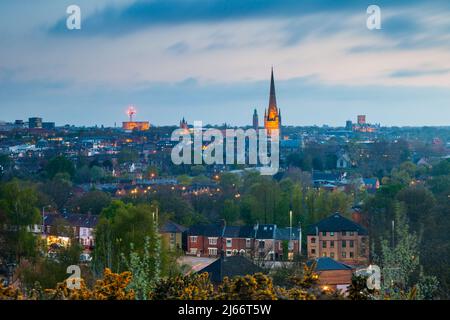 Die Nacht fällt über Norwich, Norfolk, England. Die Kathedrale von Norwich dominiert die Skyline. Stockfoto