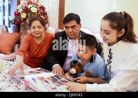 (220428) -- URUMQI, 28. April 2022 (Xinhua) -- Mayla Amatjan und ihre Familie sehen sich Fotos ihrer Tanzaufführungen zu Hause in Urumqi, der Hauptstadt der Autonomen Region Xinjiang Uygur im Nordwesten Chinas, an, 24. April 2022. Vor kurzem wurde in Urumqi ein Tanzdrama auf der Grundlage der Geschichte von Zhang Qian, einem königlichen Gesandten der westlichen Han-Dynastie (202 v. Chr. bis 25 n. Chr.), der vor über 2.000 Jahren in die westlichen Regionen reiste und schließlich zur Eröffnung der Seidenstraße führte, auf die Bühne gebracht. „Als Tänzerin der ethnischen Gruppe der Uyguren bedeutet es mir, an einem solchen historischen Tanzdrama teilzunehmen, viel, chinesische Geschichten zu erzählen und zu erzählen Stockfoto