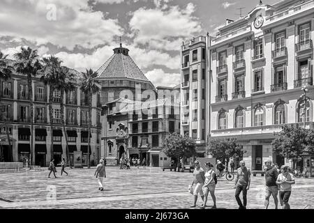 Schwarz-weiß-Bild der Plaza de la Constitucion, Malaga, Spanien mit Menschen, die unter hellem Himmel mit flauschigen Wolken durch sie schlendern Stockfoto