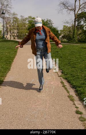 Park des Buttes Chaumont. Nahaufnahme einer Frau, die hopscotch spielt Stockfoto