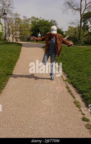 Park des Buttes Chaumont. Nahaufnahme einer Frau, die hopscotch spielt Stockfoto