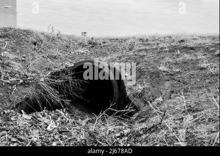 HDPE-Drainage unter einer Straßeneinfahrt. Das Rohr dient zur Förderung von Regenwasser zwischen Gräben. Stockfoto