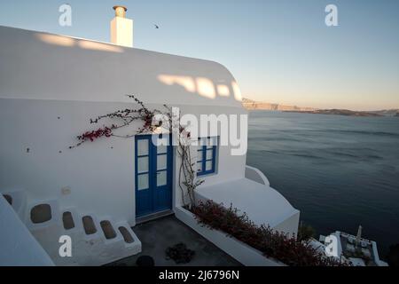 Oia, Griechenland - 11. Mai 2021 : Ein wunderschönes weiß getünchtes Wohnhaus mit Blick auf die Ägäis in Oia Santorini Stockfoto