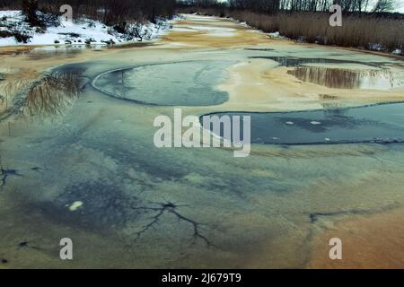 Wasseröffnung (Polynya), rundes Auftauloch im Eis im verfaulten Wintereis, Auftauen als Krebsmetastasen - ein gefährlicher Ort Stockfoto