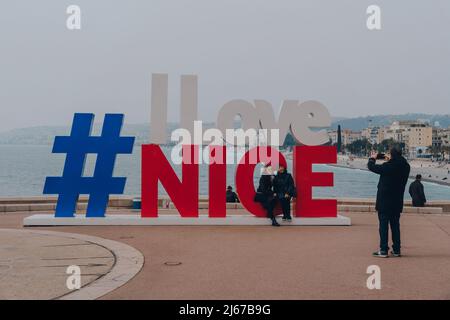 Nizza, Frankreich - 11. März 2022: Touristen, die am Schild „I Love Nice“ Fotos machen, in Nizza, einem berühmten Touristenziel an der französischen Riviera. Stockfoto