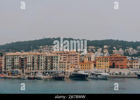 Nizza, Frankreich - 11. März 2022: Yachten vor den pastellfarbenen Gebäuden im Hafen von Nizza, einem berühmten Touristenziel an der Fre, festgemacht Stockfoto